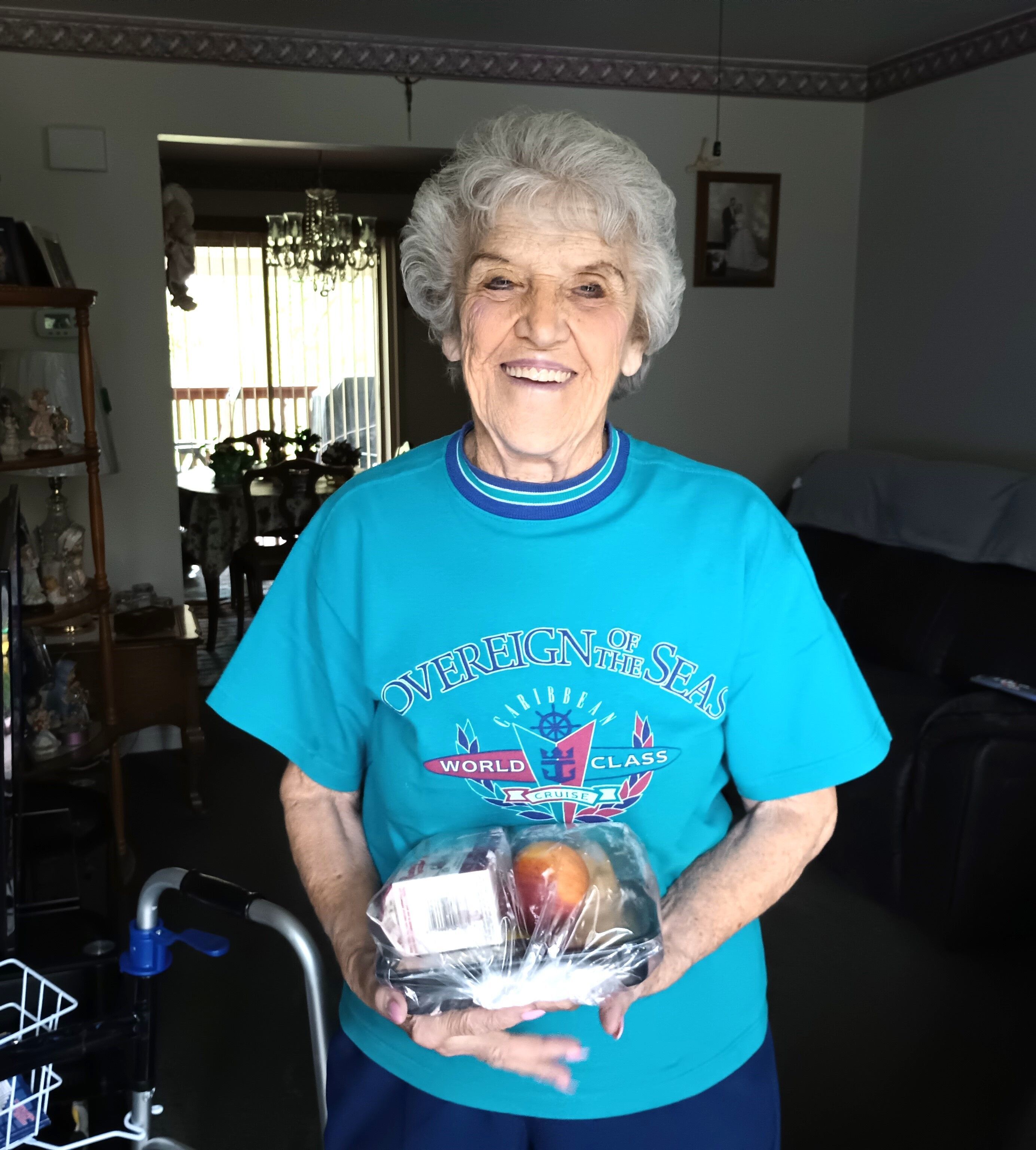 A Meals on Wheels recipient smiles as she receives her delivery of healthy, fresh food.