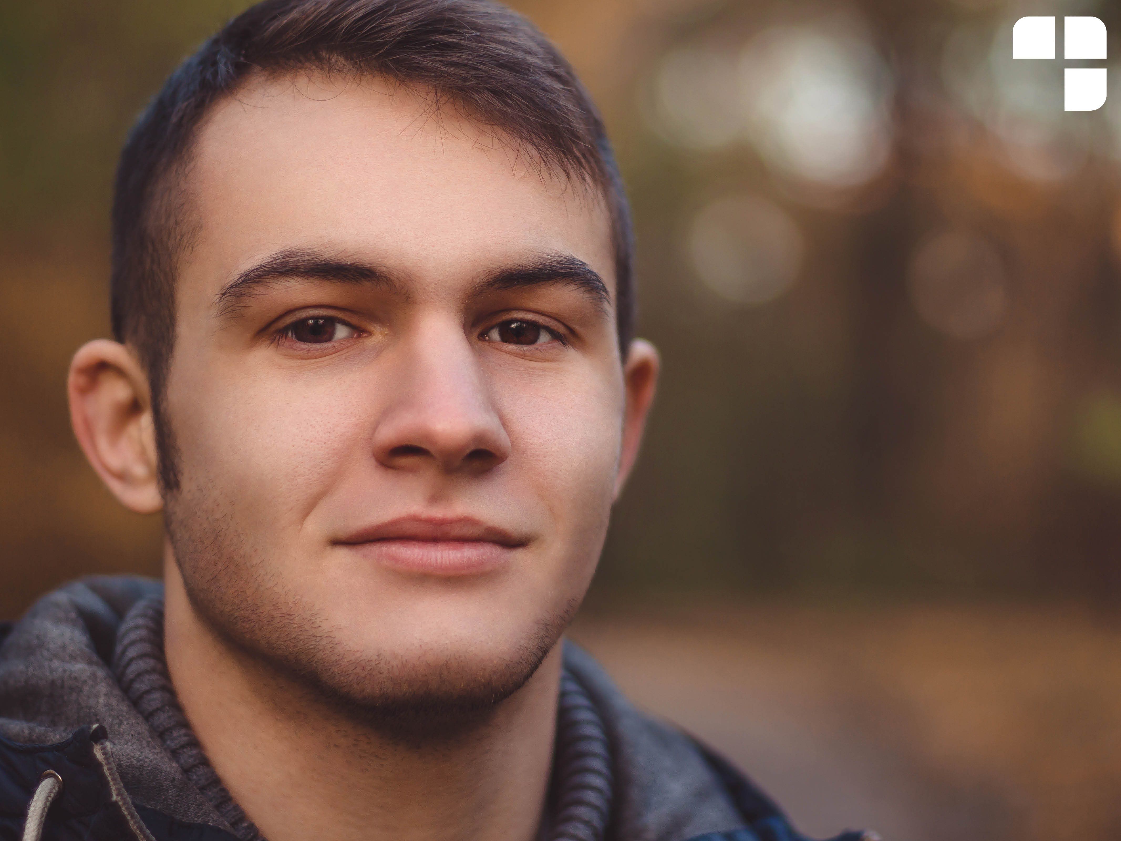 A teen boy looking at the camera with a soft smile.