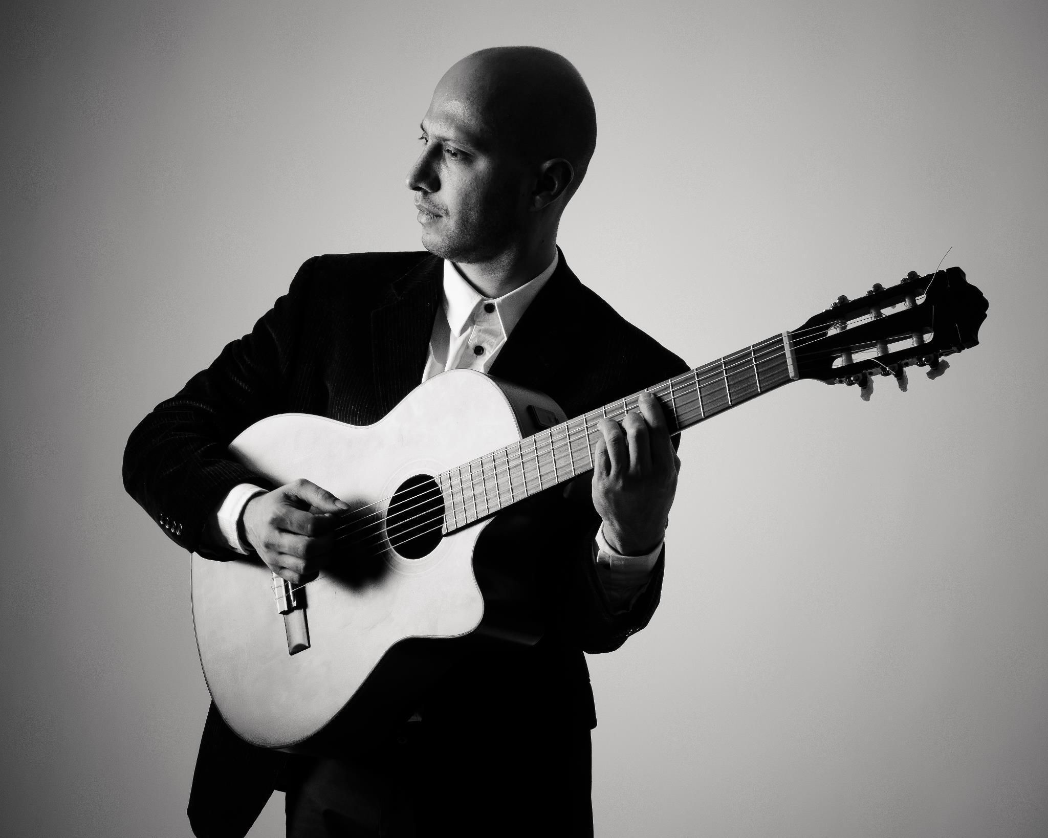 musician Daniel Reyes Llinás holding an acoustic guitar