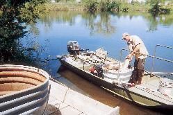 Man doing chemical treatment to a lake.