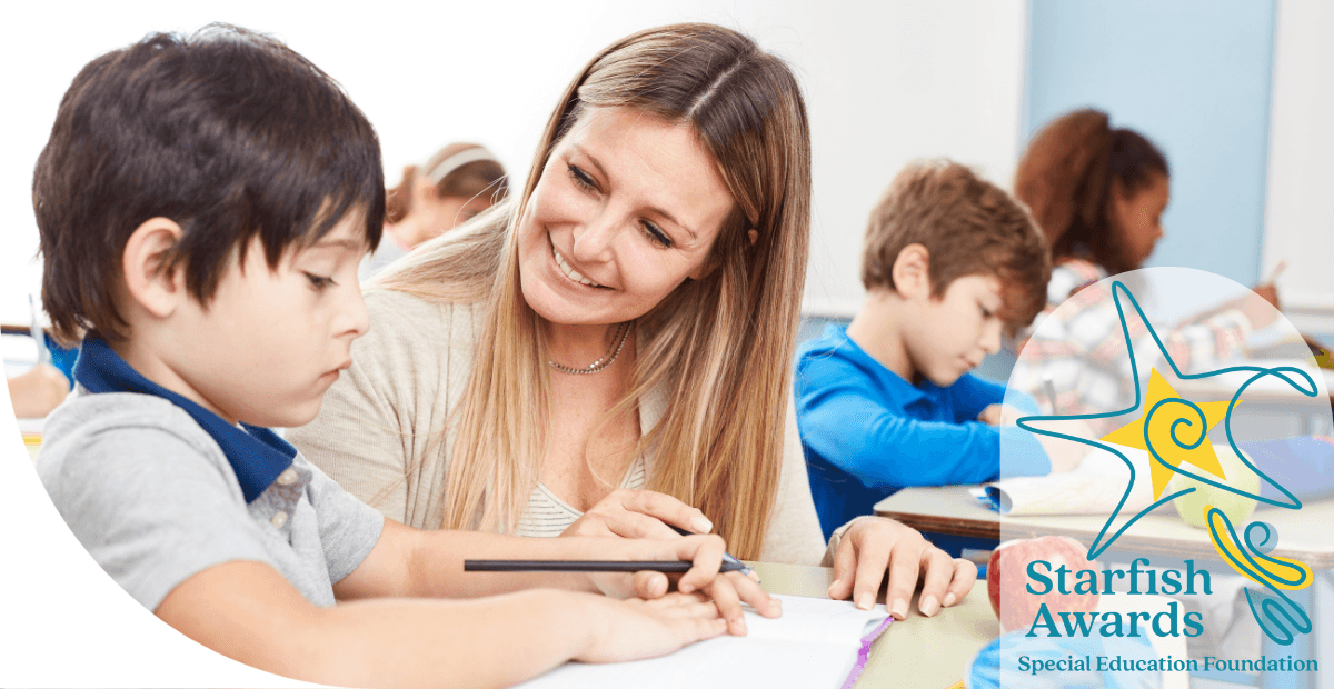 woman sitting with a boy at a desk holding a pen in his hand