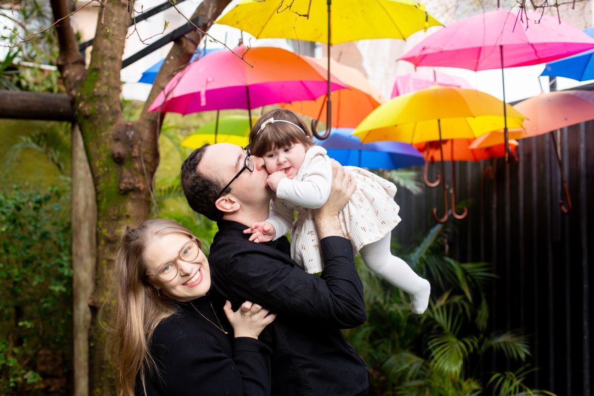 Katarina and family posing with colorful umbrellas in background.