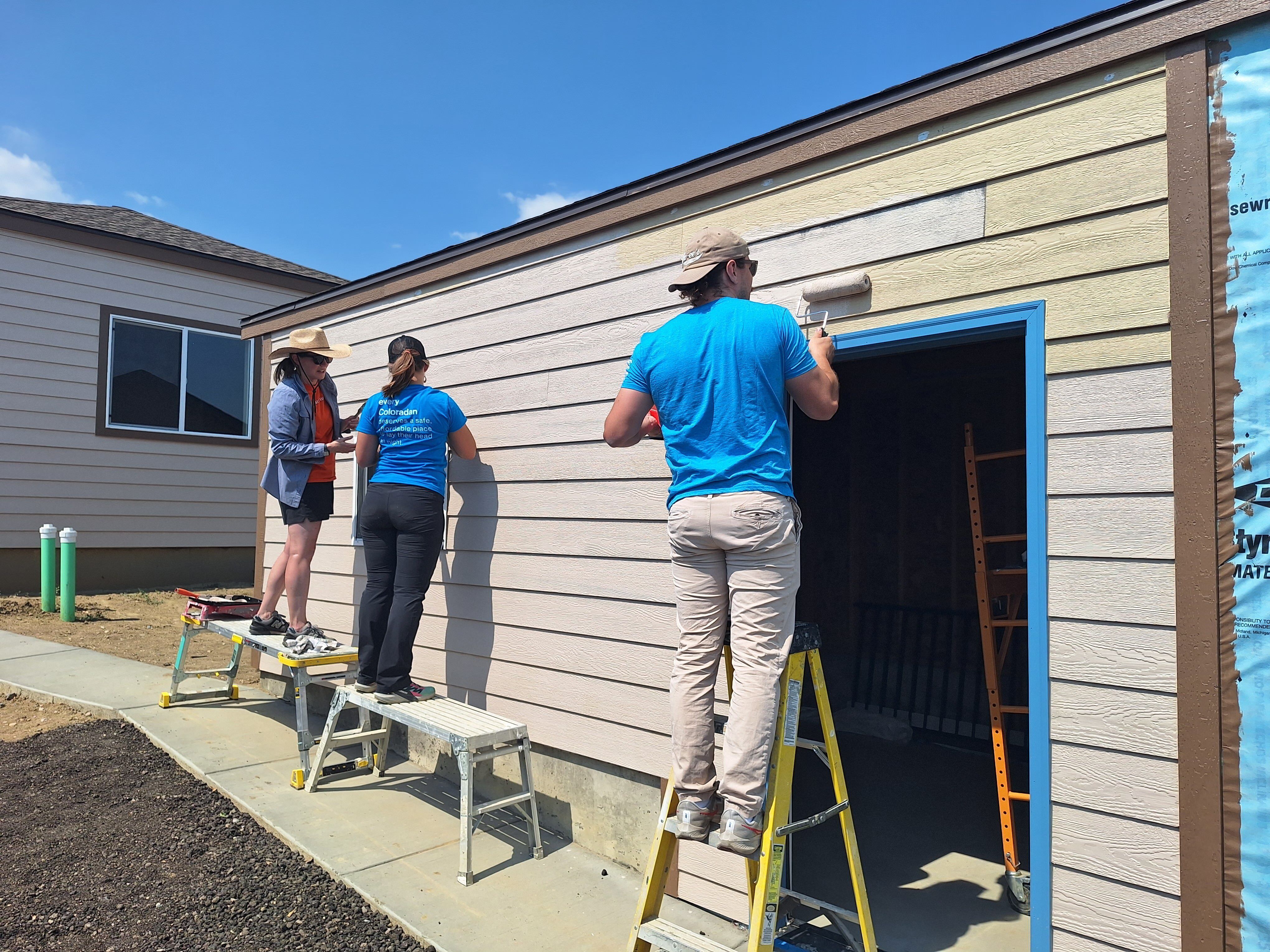 Habitat Colorado Build: Volunteer Painting outside of the garage