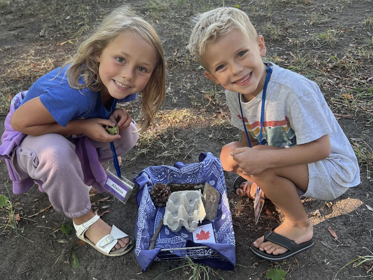 Two students smiling and posing with their nature finds.