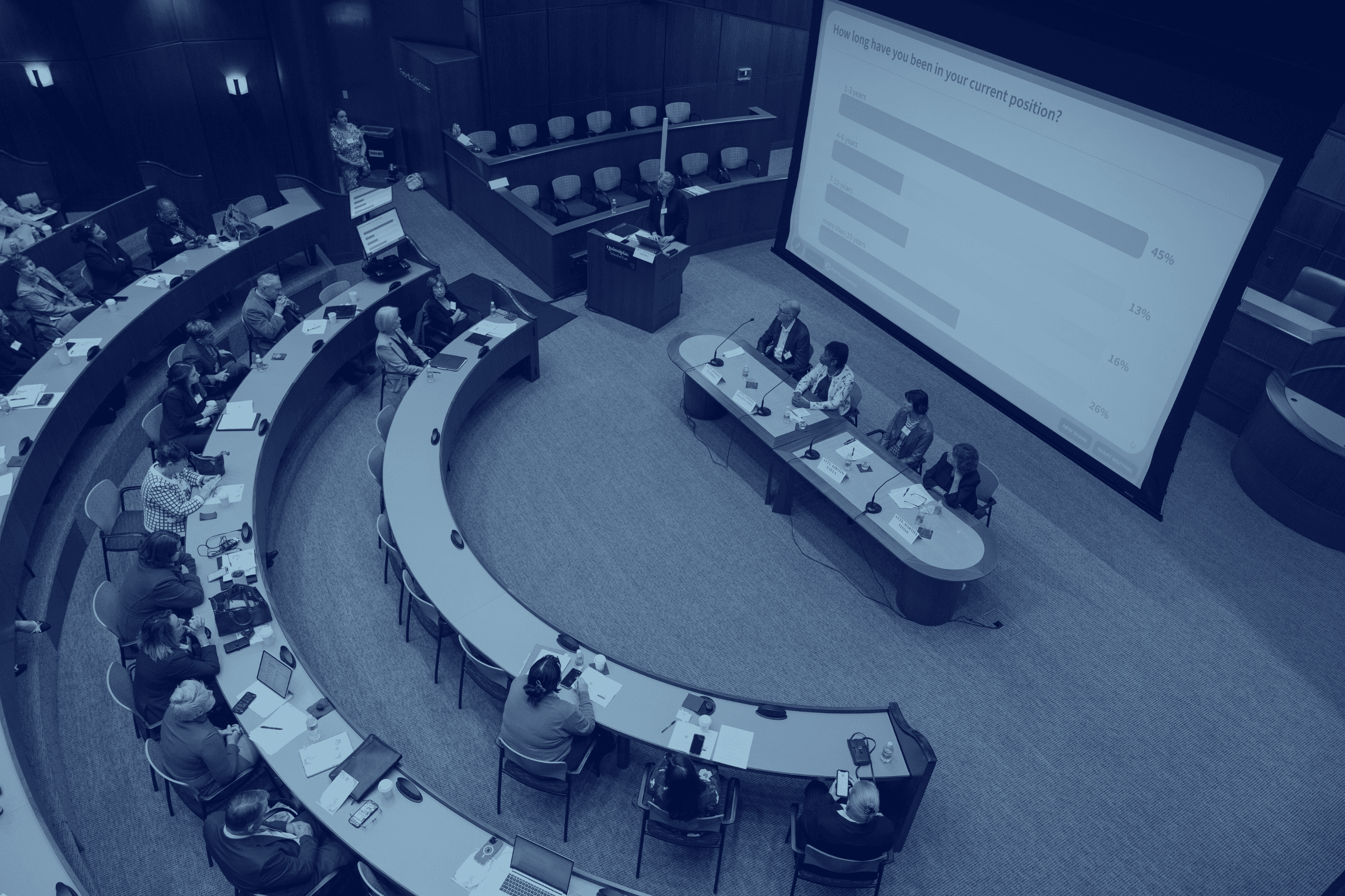 People in lecture hall. Notebook in one person's lap.