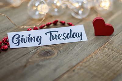 Image of Giving Tuesday place card on wooden table