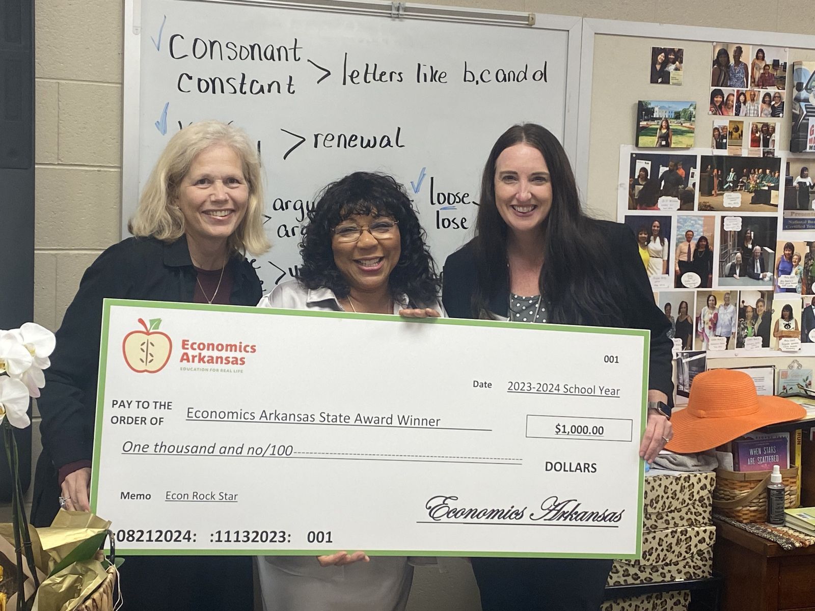 group of adults presenting large check and award to teacher