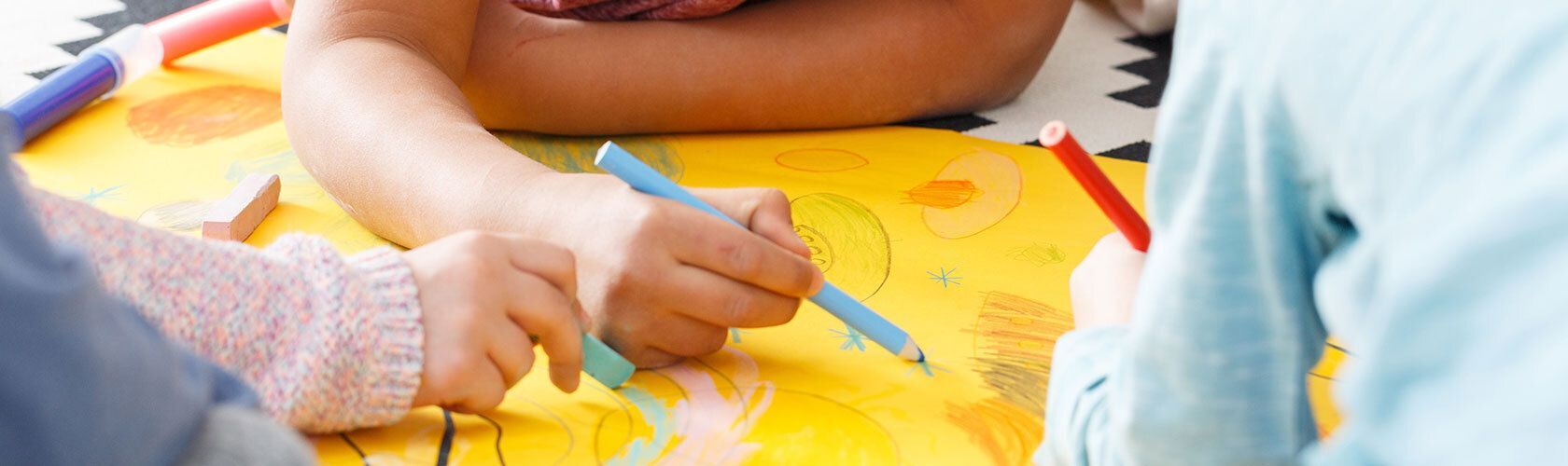 Hands using pencils to write on paper