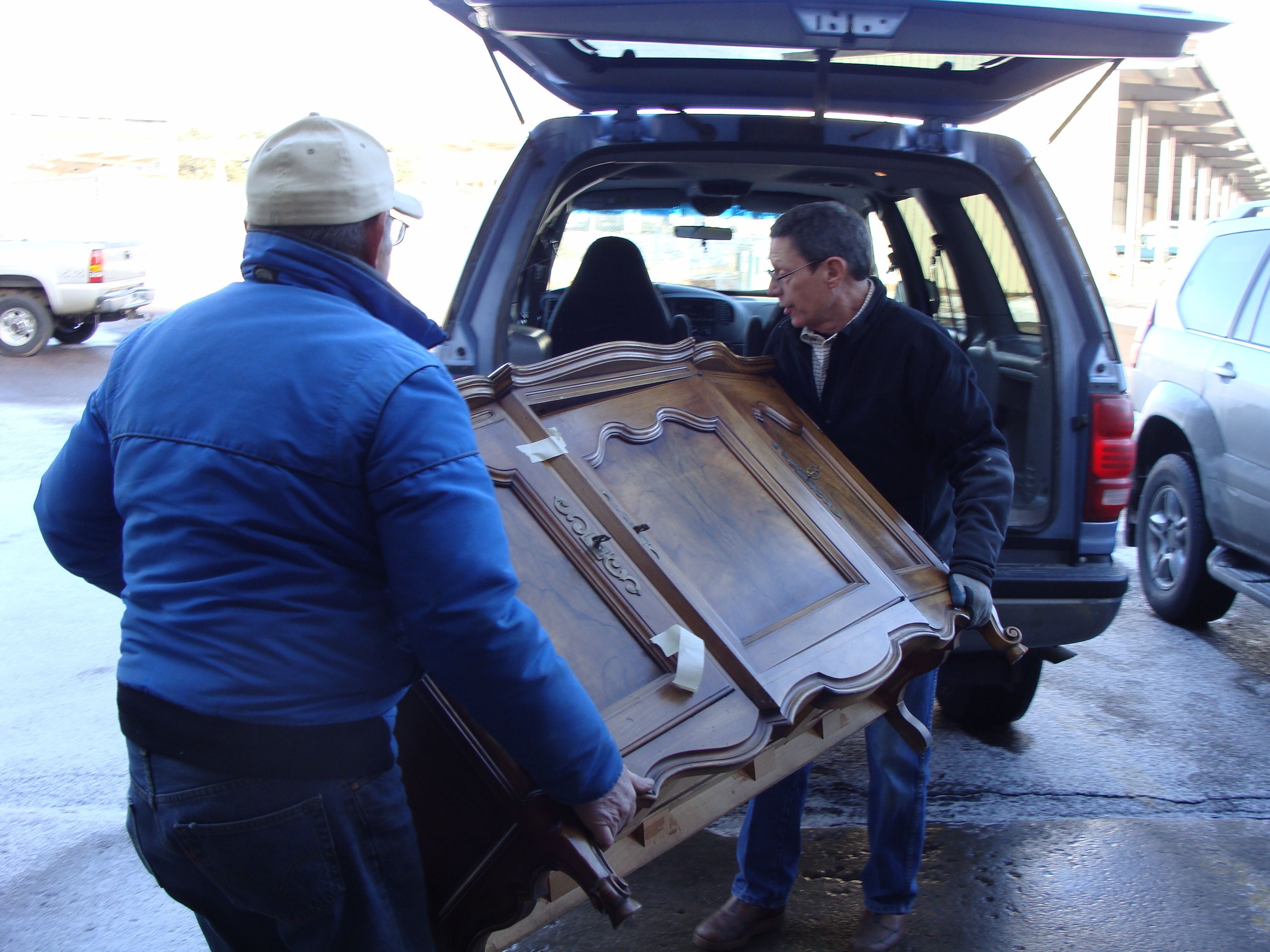 People unloading furniture from a vehicle at the ReStore