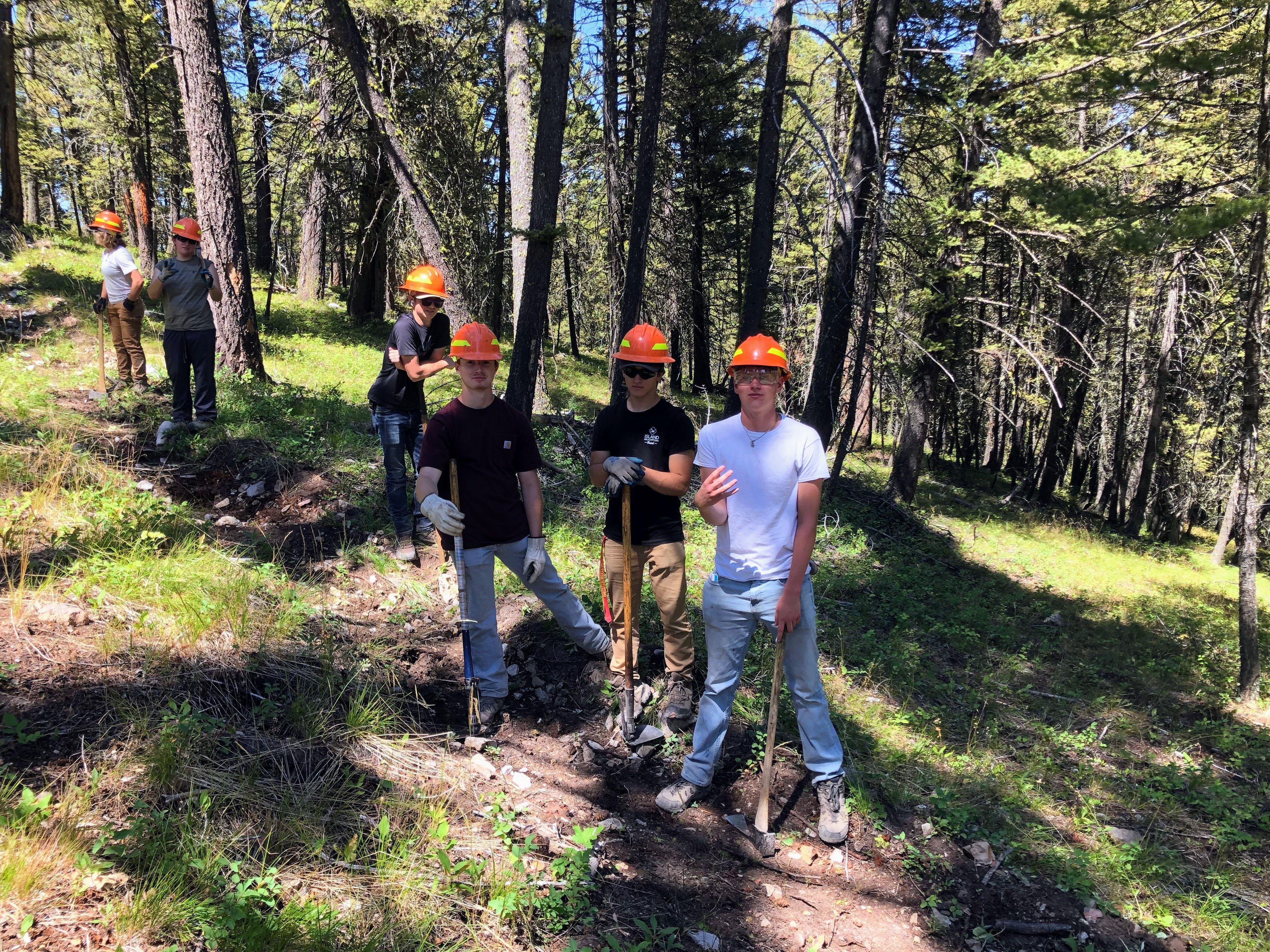 A youth crew poses while they are at work digging a fire line.