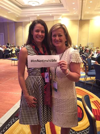 Photo of Dr. Jennifer Lentz and Carol Brill holding a sign that reads #ImNotInvisible