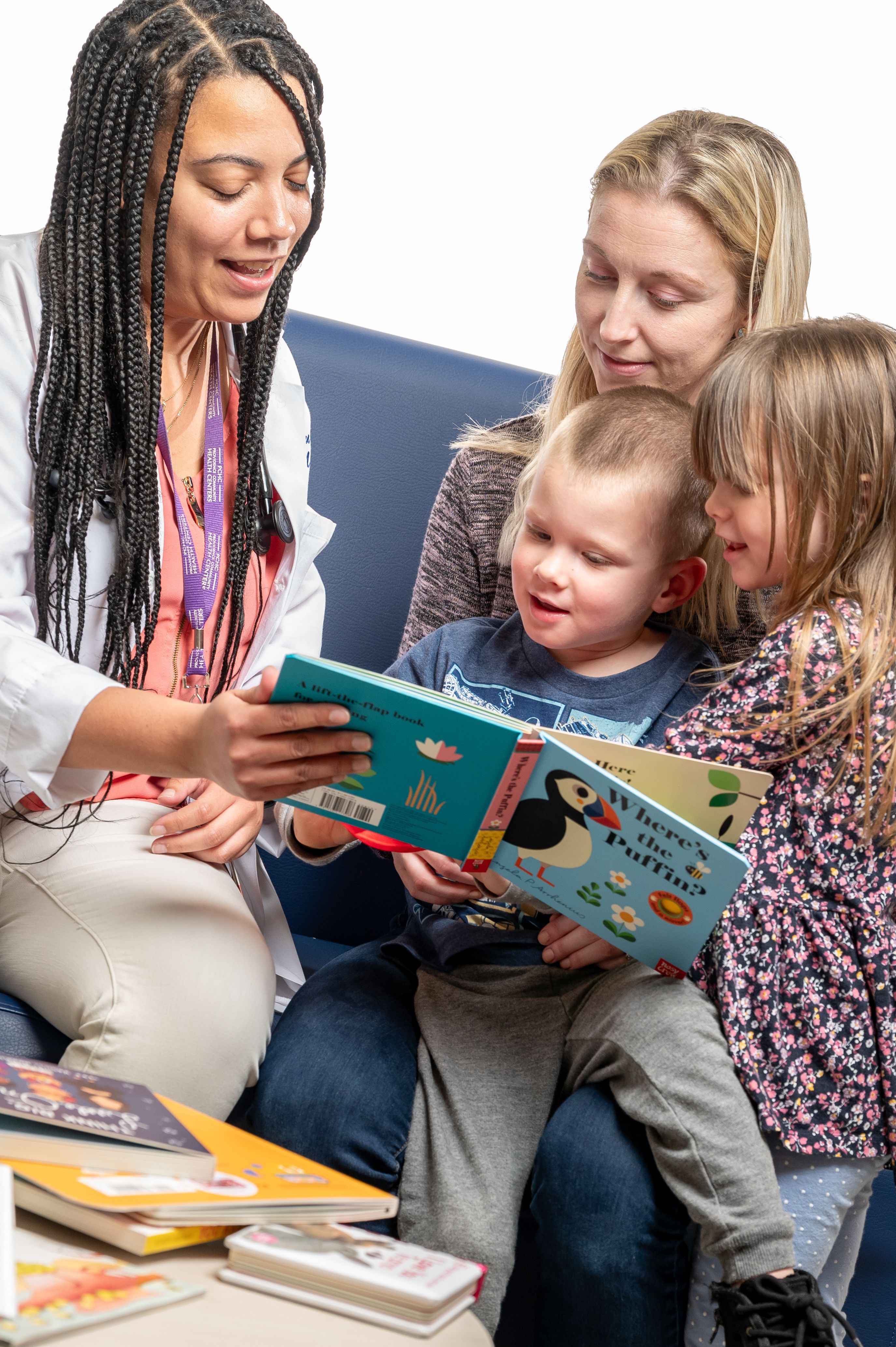 Doctor, mother, and two children read book together