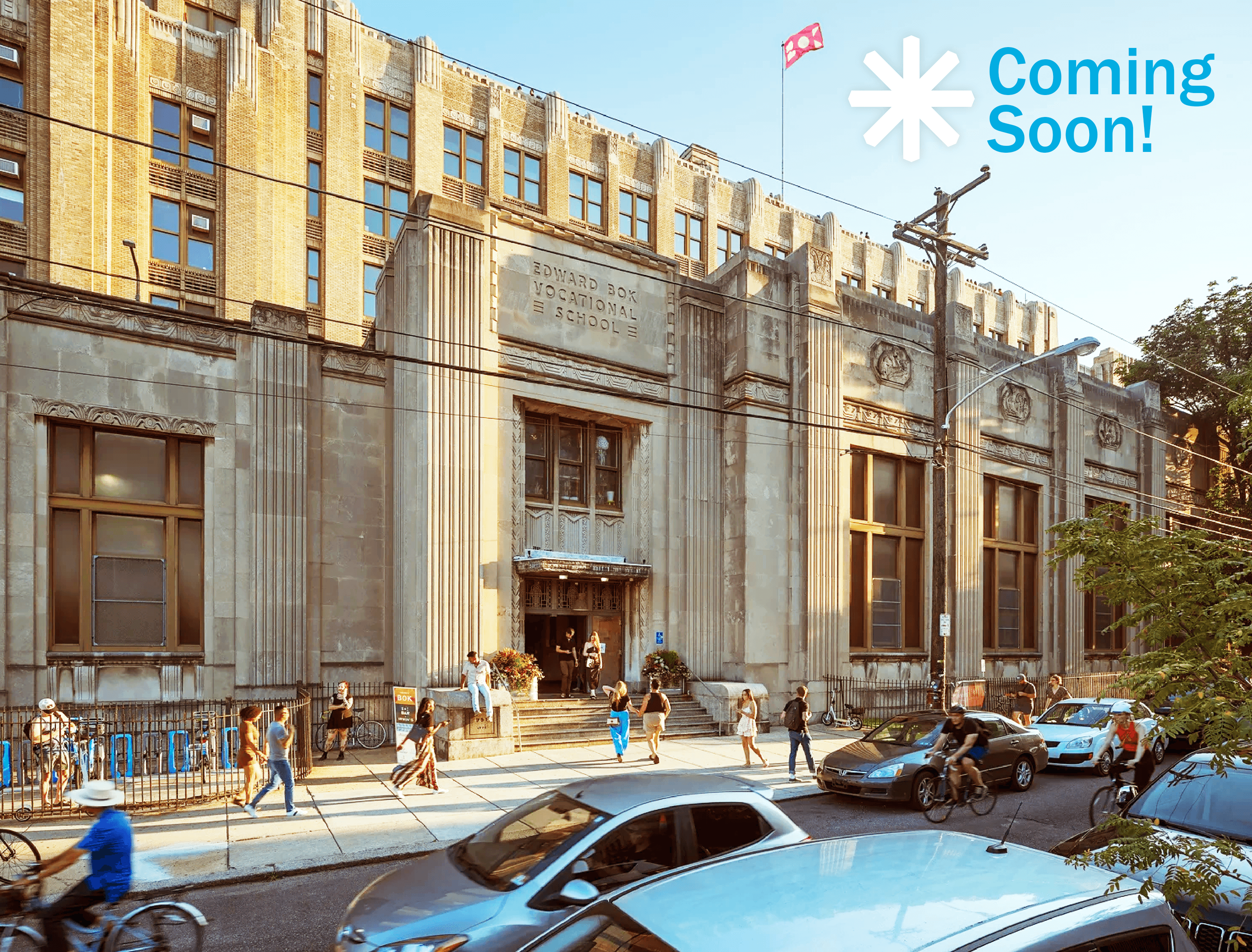 Sunny exterior photo of the Bok building with people walking by showing a vibrant neighborhood scene.