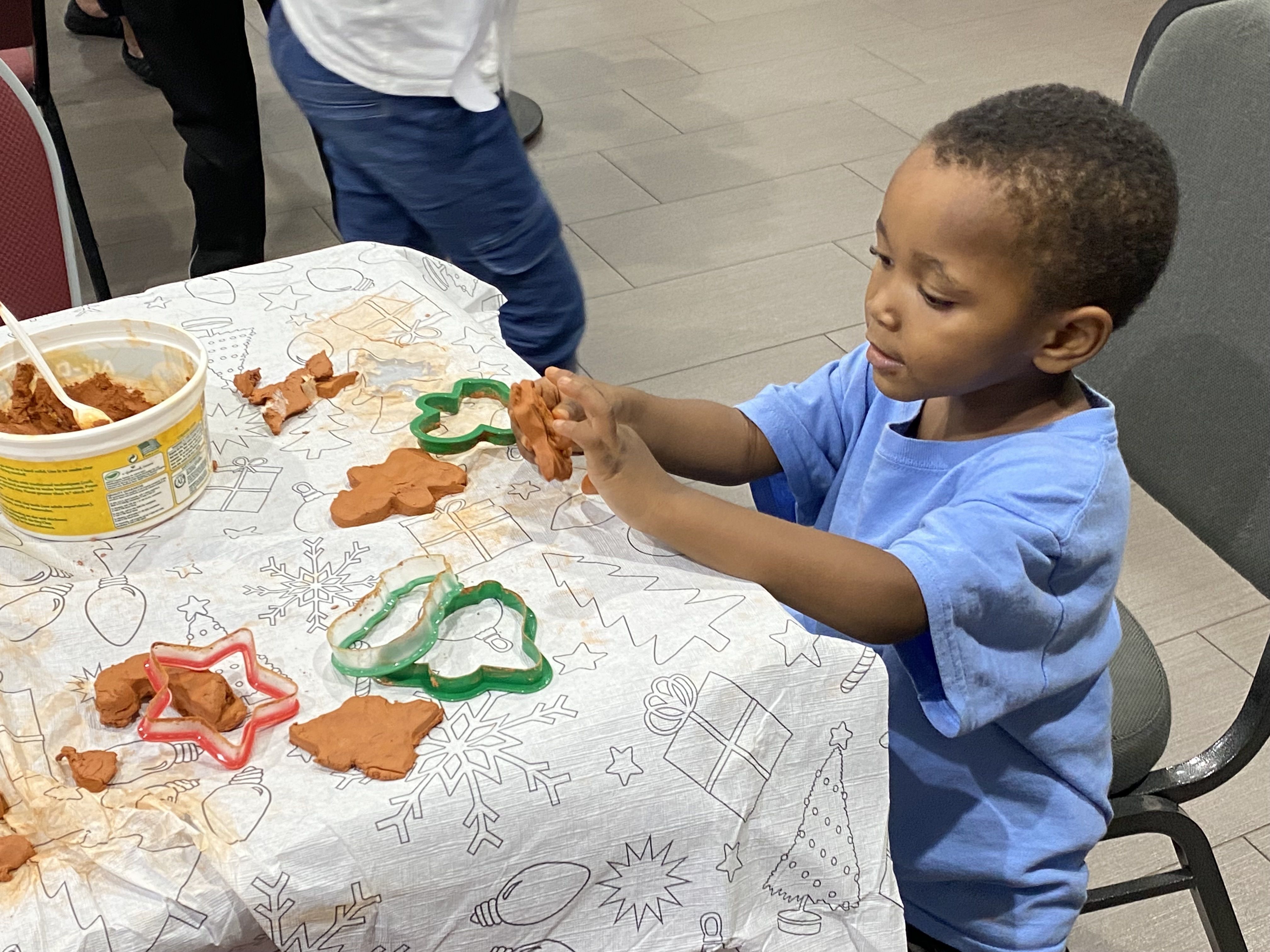A child at the Warm Nights Shelter in Prince George's County, Md. makes holiday ornaments during a "Pop Up" Playtime event in December 2021. 