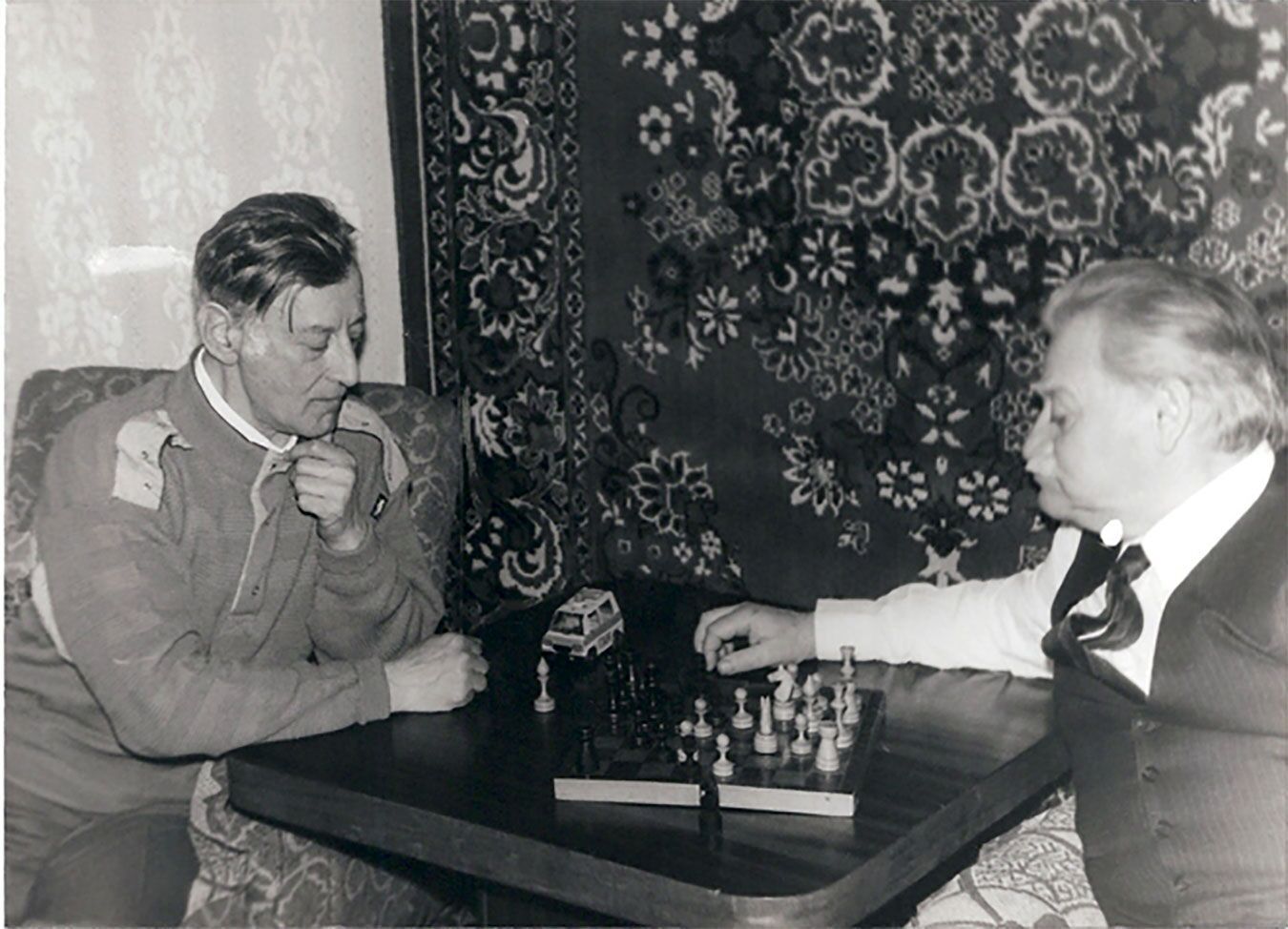 Gregory's father (L) playing chess with Bella's father (R)