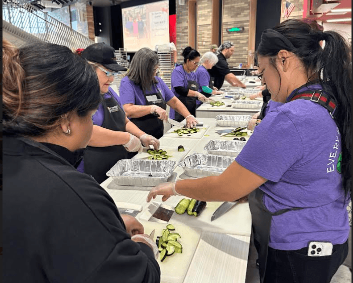 Littleton Public Schools kitchen managers cutting up vegetables in purple shirts and black aprons