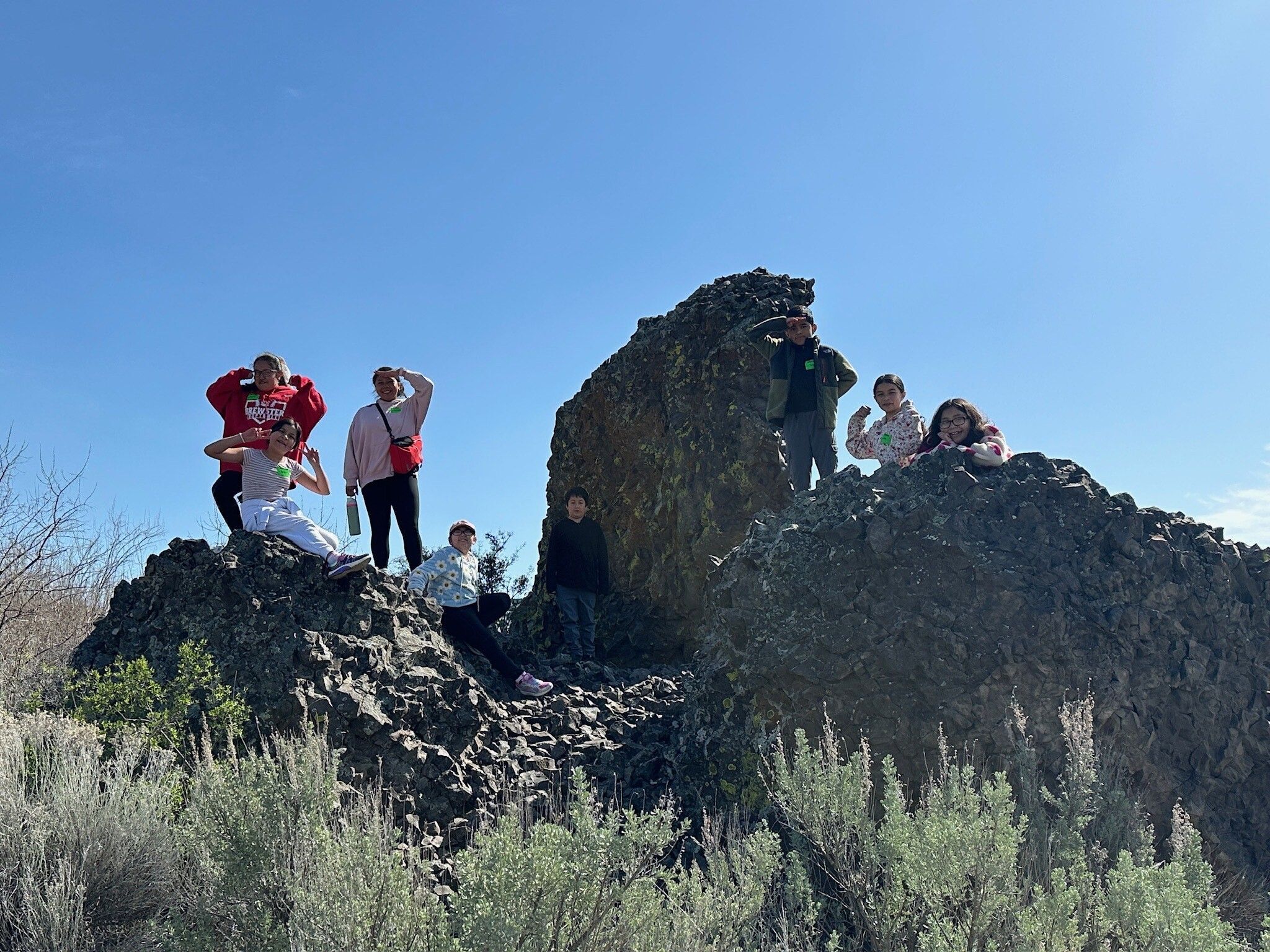 A group of students posing on a rock fixture at Bridgeport State Park during their Field Day.