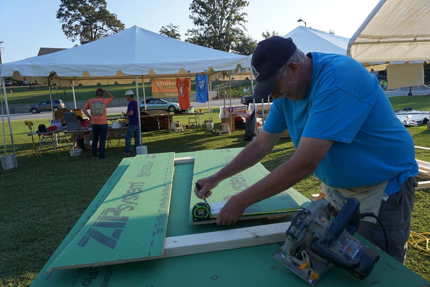 A PCHFH volunteer measures green wall sheathing donated by Huber Engineered Woods.