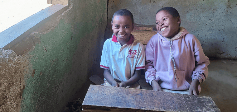 Two friends enjoying each other in their fourth grade classroom