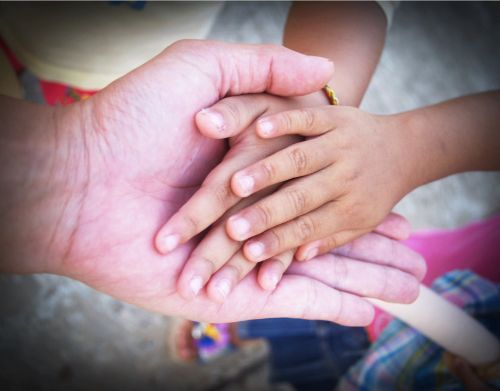 image of adult holding child's hands
