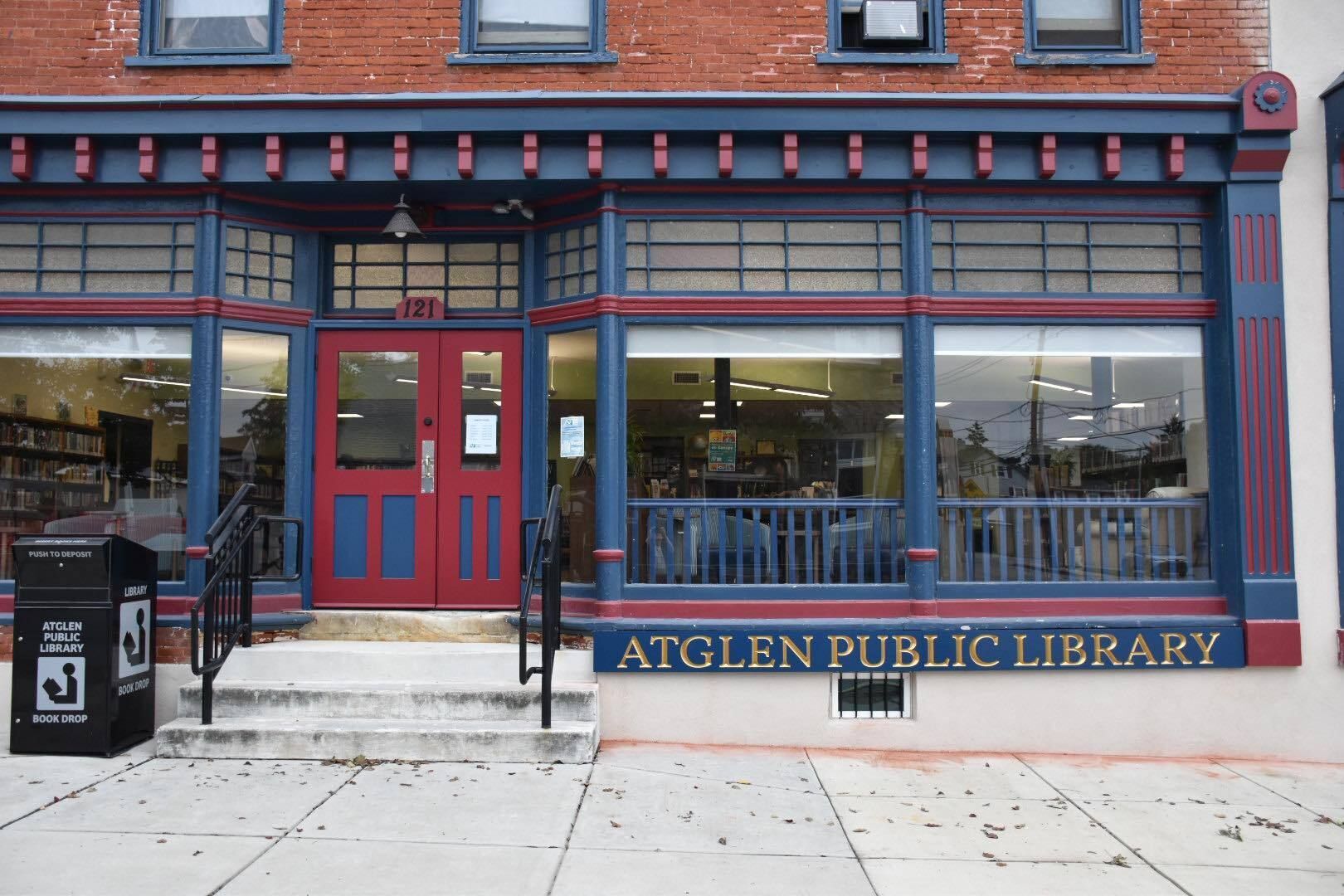 Two comfortable chairs face the bright windows in the Young Adult section.