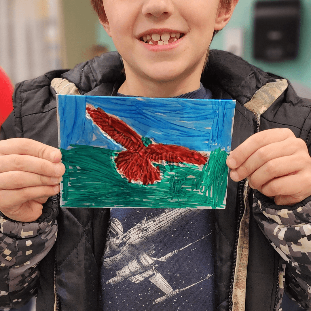 Boy holding tin foil bird art