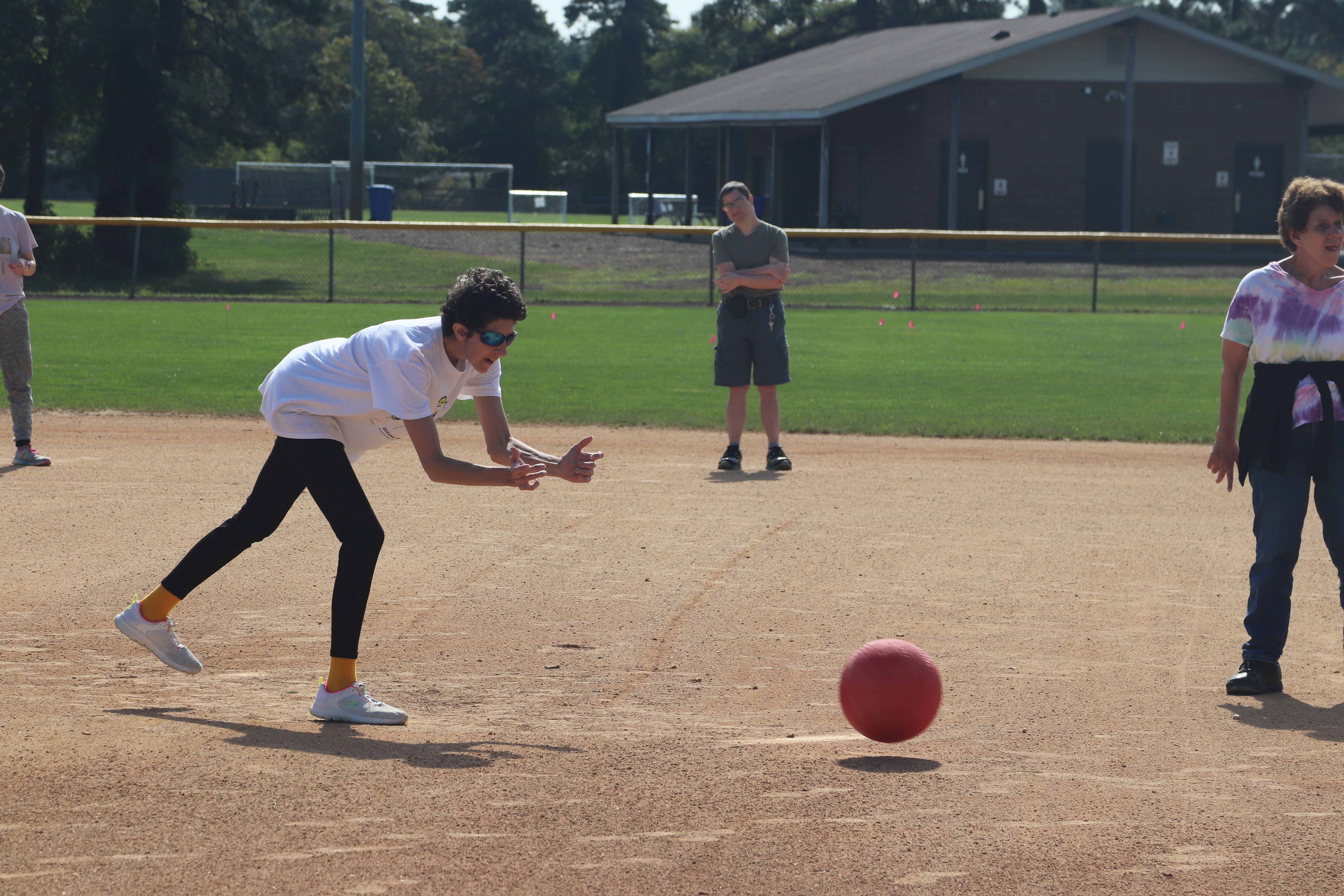 Woman rolling a kickball 