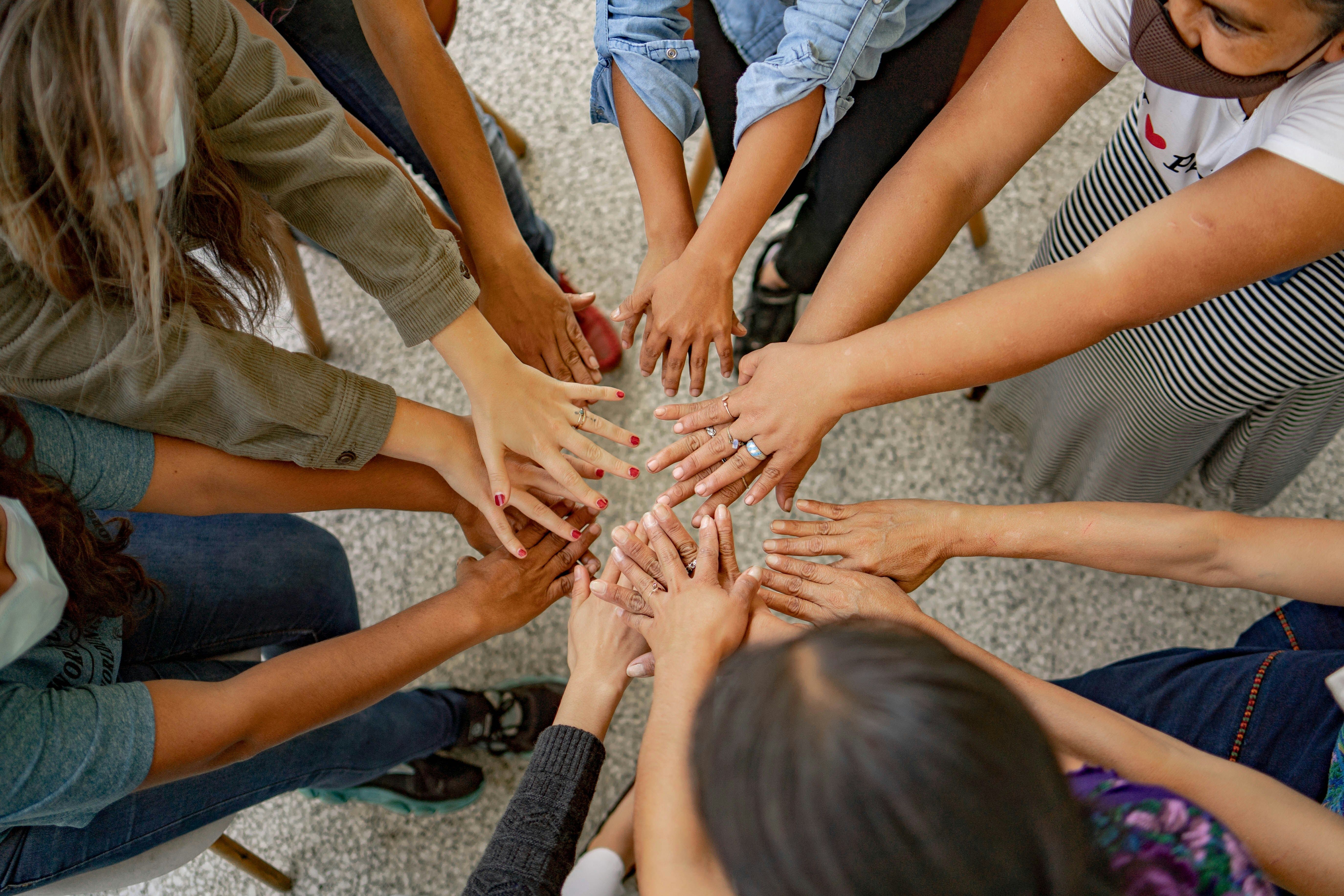 people standing in circle holding hands