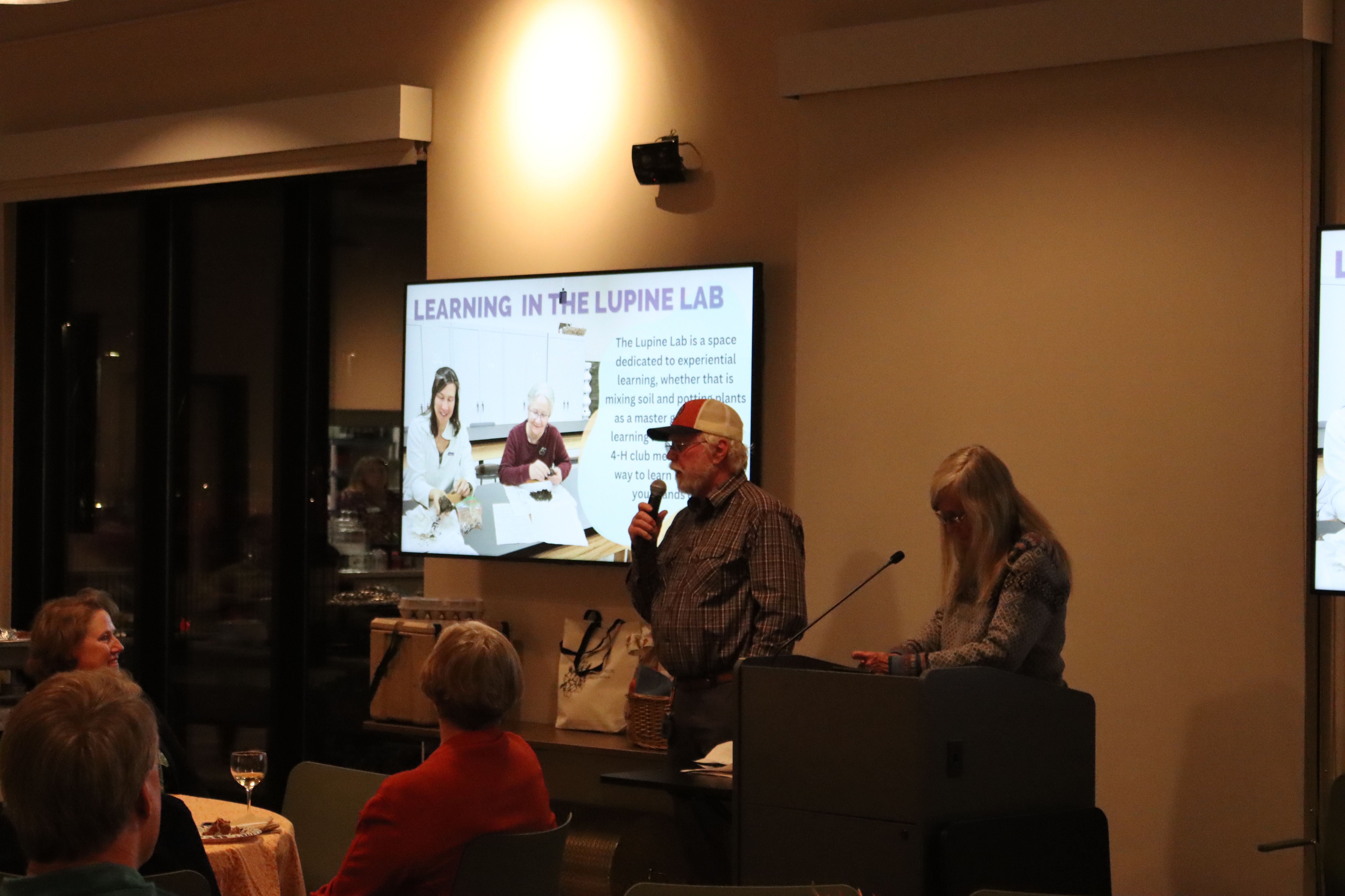 Man with microphone introducing the Lupine Lab presentation.