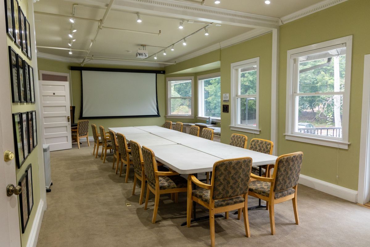 Several chairs set up around 6 long tables to mimic the conference style set-up for the Bird Fest Room.