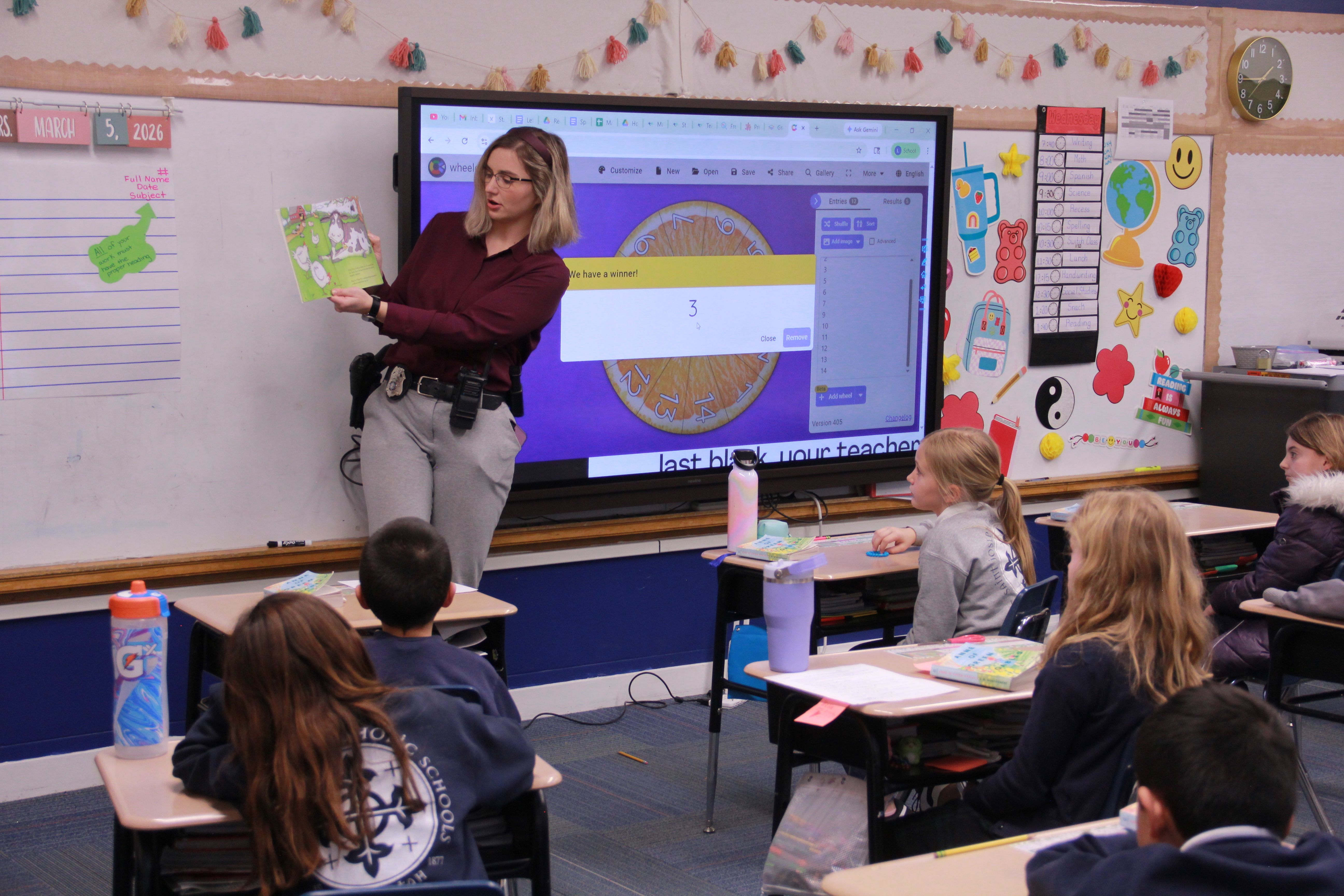 A member of law enforcement reading to a classroom full of young children