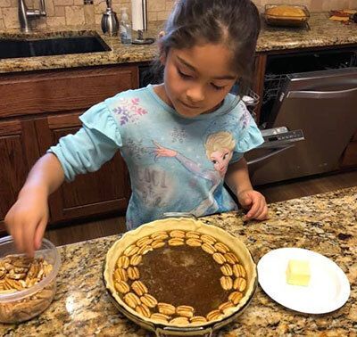 Child making a pecan pie.