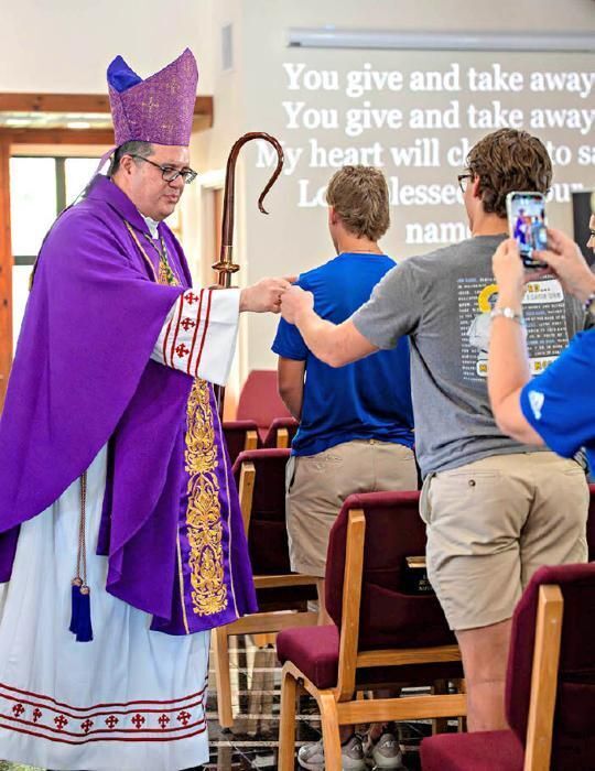 Bishop Manuel de Jesús Rodríguez fist-bumps a student during Mass at the annual Re-Focus retreat Feb 27. 2026.