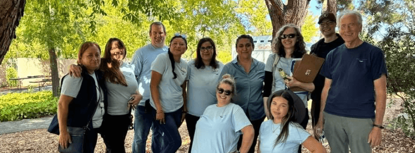 a group of smiling ParentsCAN staff stand together under trees
