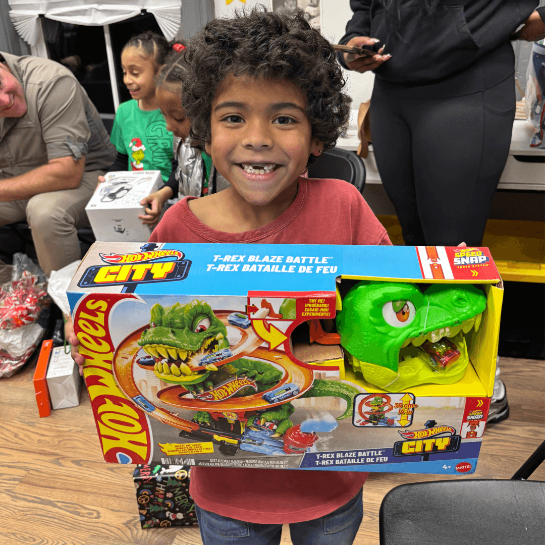 Photo features a student from our afterschool program with a gift from NetJets.