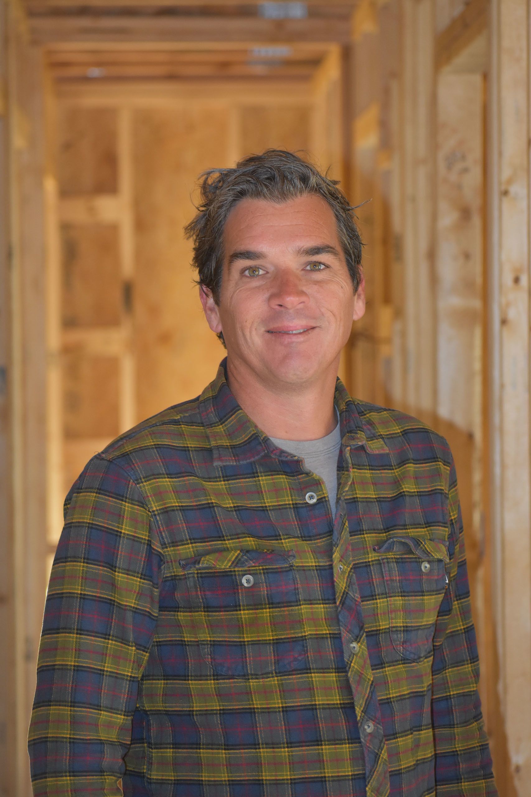 Construction Coordinator Chris Mastandrea smiles standing in a Habitat house