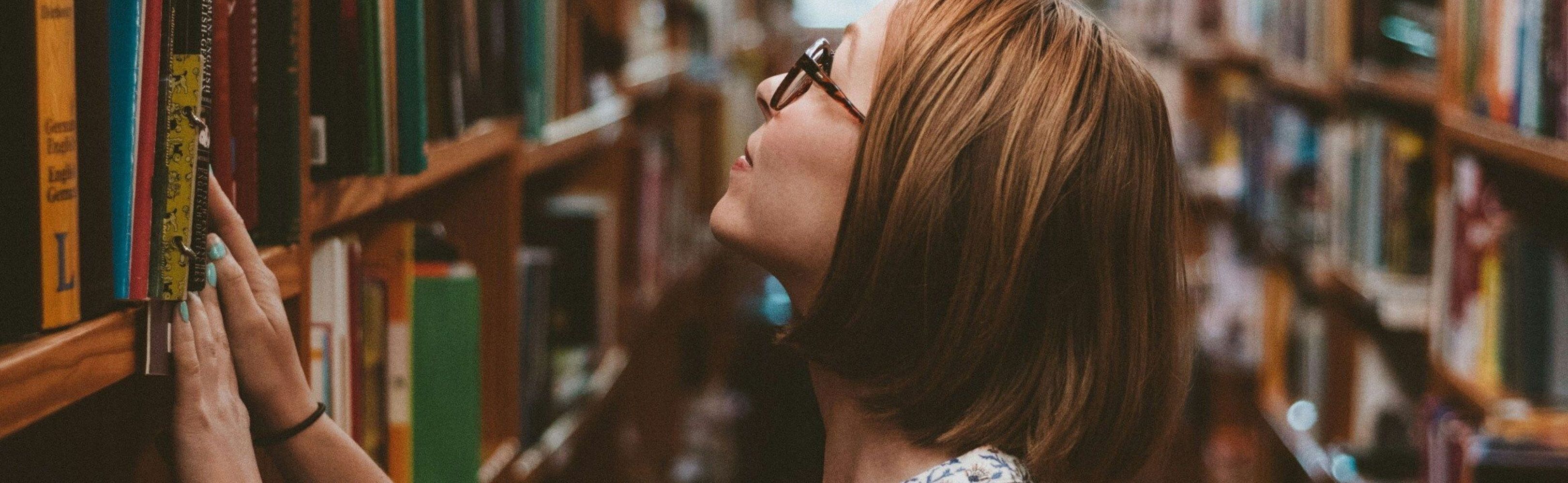 Women looking at book stack. 