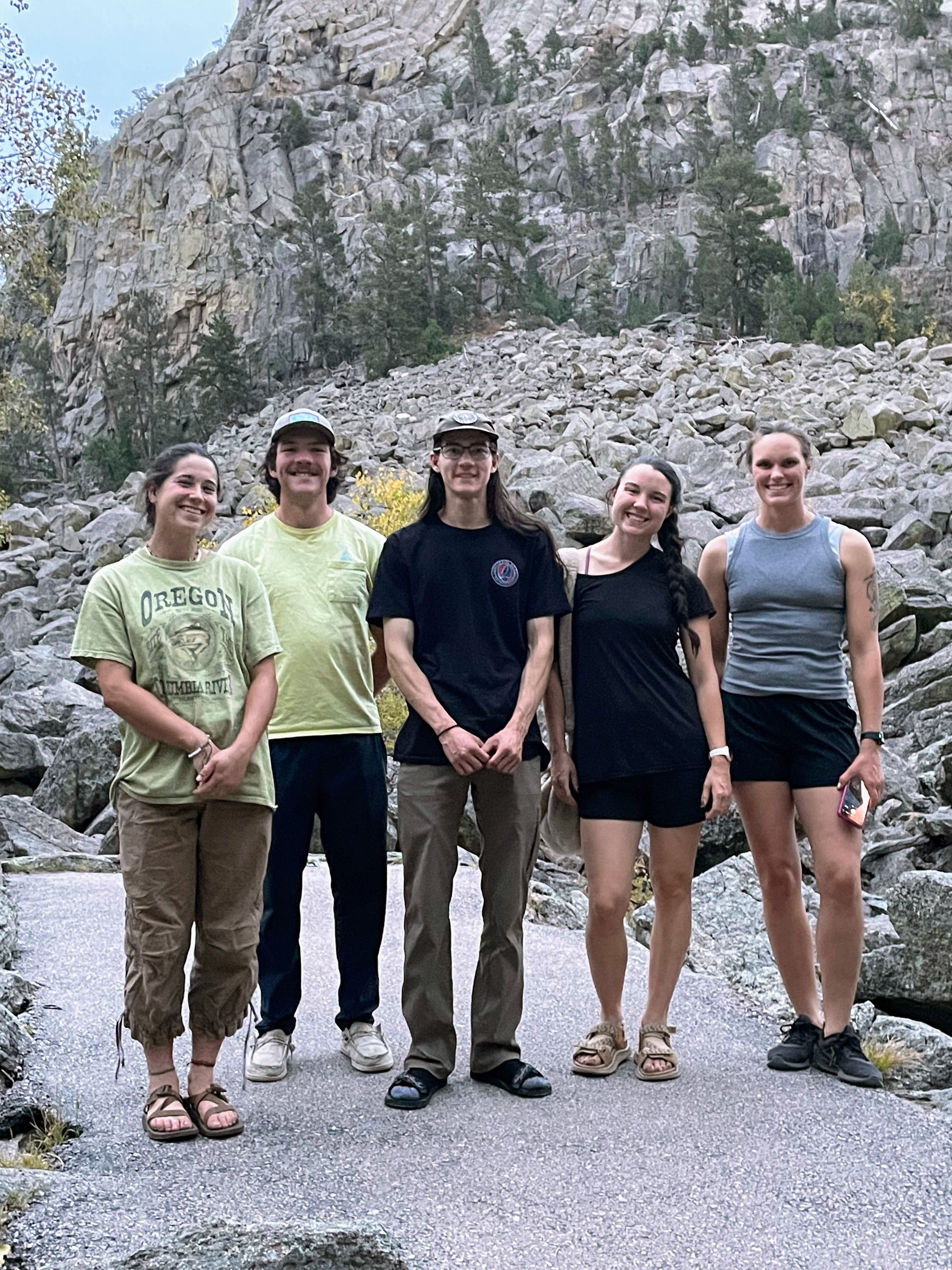 A crew stands smiling at the camera.