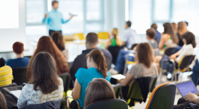 Maine State Capitol in late fall with multi-directional sign post in foreground directing website visitors to many of the health coverage options available in Maine