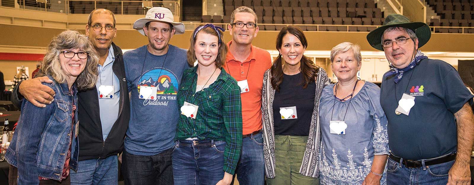 A group of PSC patients and caregivers stand smiling together at a PSC Partners conference.