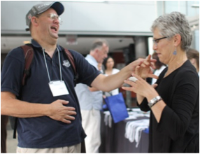 A picture of two people greeting each other at the usher syndrome conference.