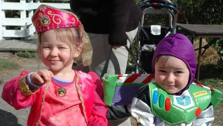 A picture of two young children dressed up in Halloween costumes. One is dressed up as Jasmine from Aladdin and one is Buzz Lightyear from Toy Story