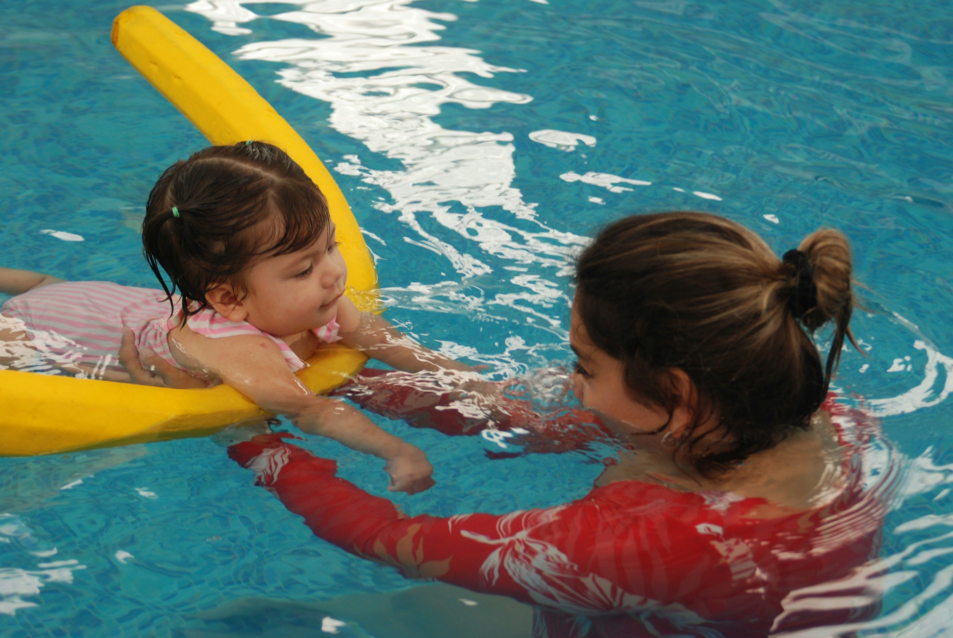 Adult teaching infant swim class