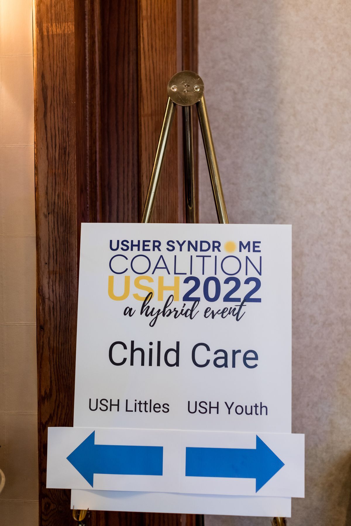 A sign that says Child Care. Two arrows point in opposite directions. One arrow points to the left for USH Littles, the other arrow pointing to the right is for USH Youths.