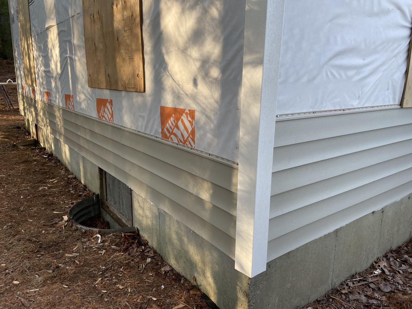 Photo of exterior corner of a house with some beige siding installed