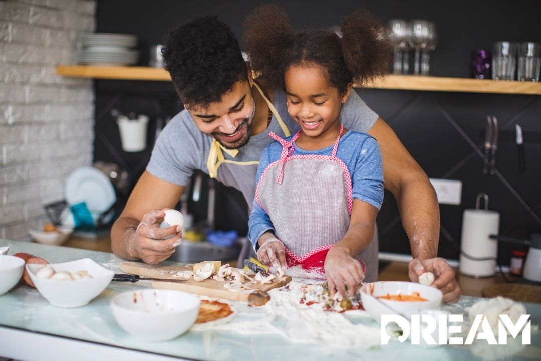 Dad and young daughter cooking together in the kitchen