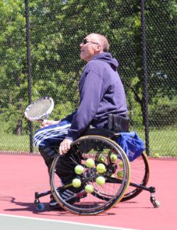 Man in wheelchair playing tennis