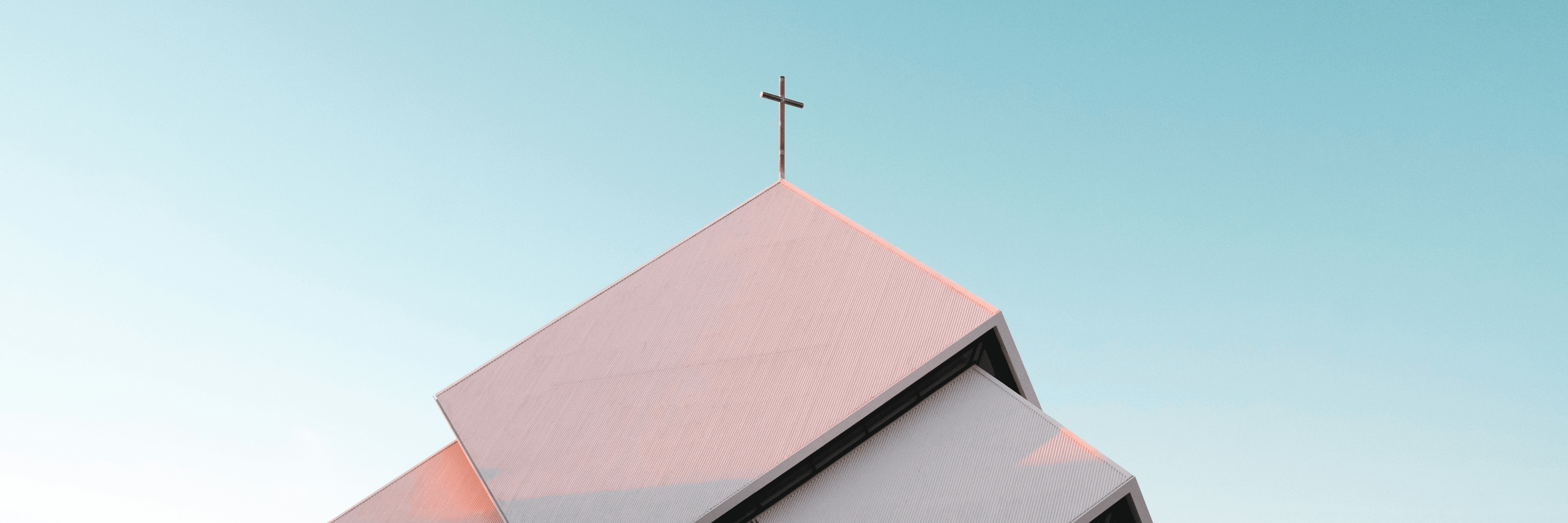 Photo of a church roof with a cross on top