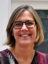 Photo of Dr. Annika Bergquist wearing a brightly colored shirt and smiling at the camera