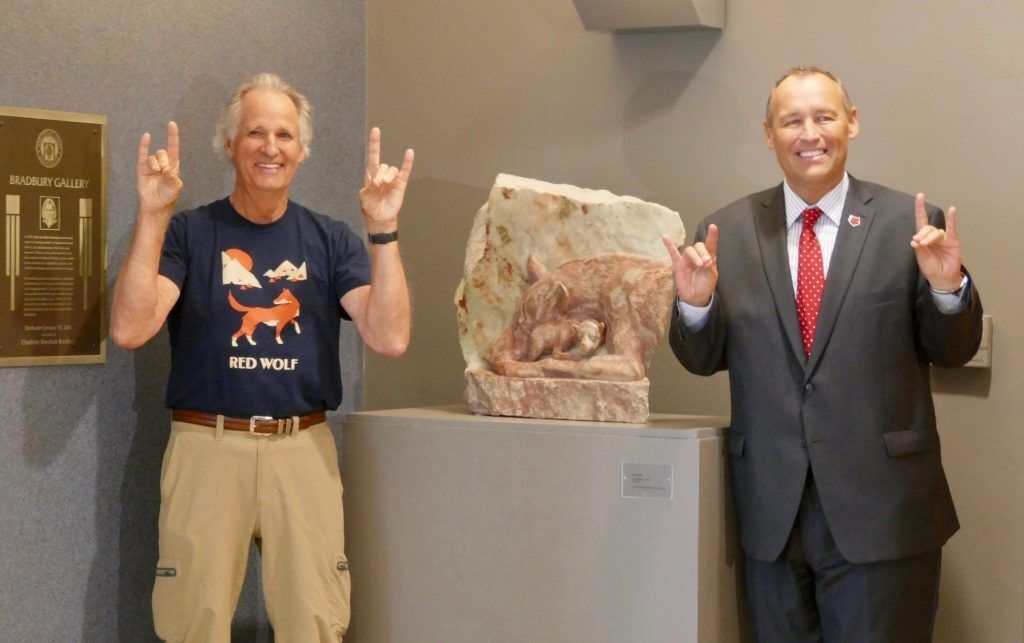 Dale & Chancellor Kelly Damphousse giving the red wolf sign with their hands at the Arkansas State unveiling